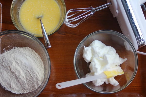bowls for cakes butter, cream and flour in clear glass bowls on a wooden countertop