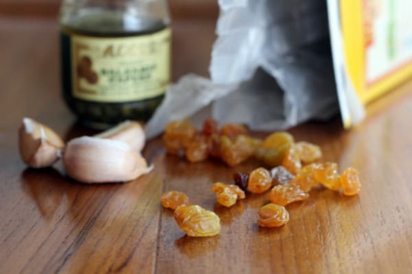 golden raisins and garlic cloves on a wooden table