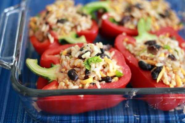 cooked stuffed bell peppers in a clear glass baking dish