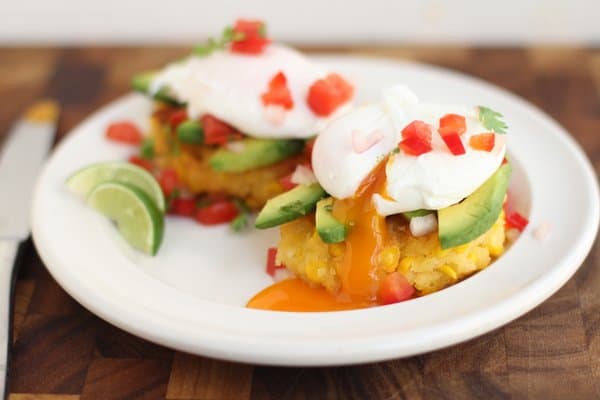 poached eggs on top of corn cakes on a white plate