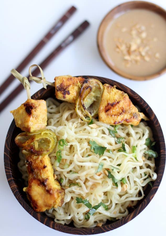 salmon skewers over ramen noodles in a wooden bowl